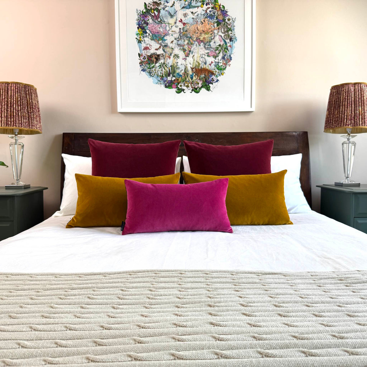 bright pink velvet cushion with burgundy and gold ochre on wooden bed