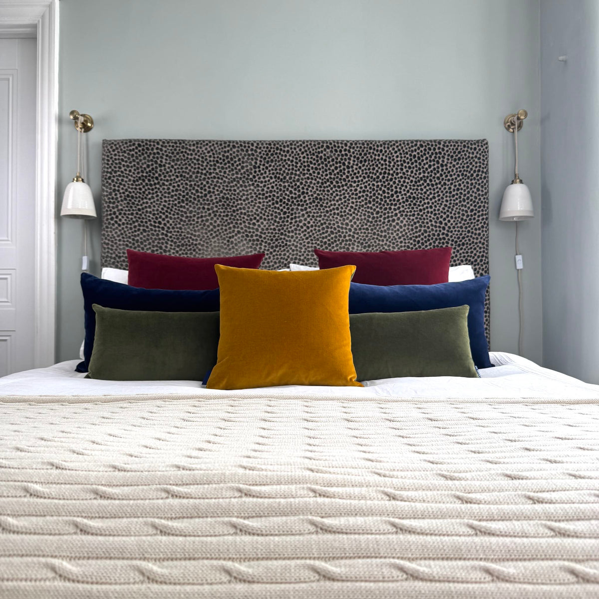 gold ochre velvet cushion with olive, navy, burgundy cushions on white and cream bedding