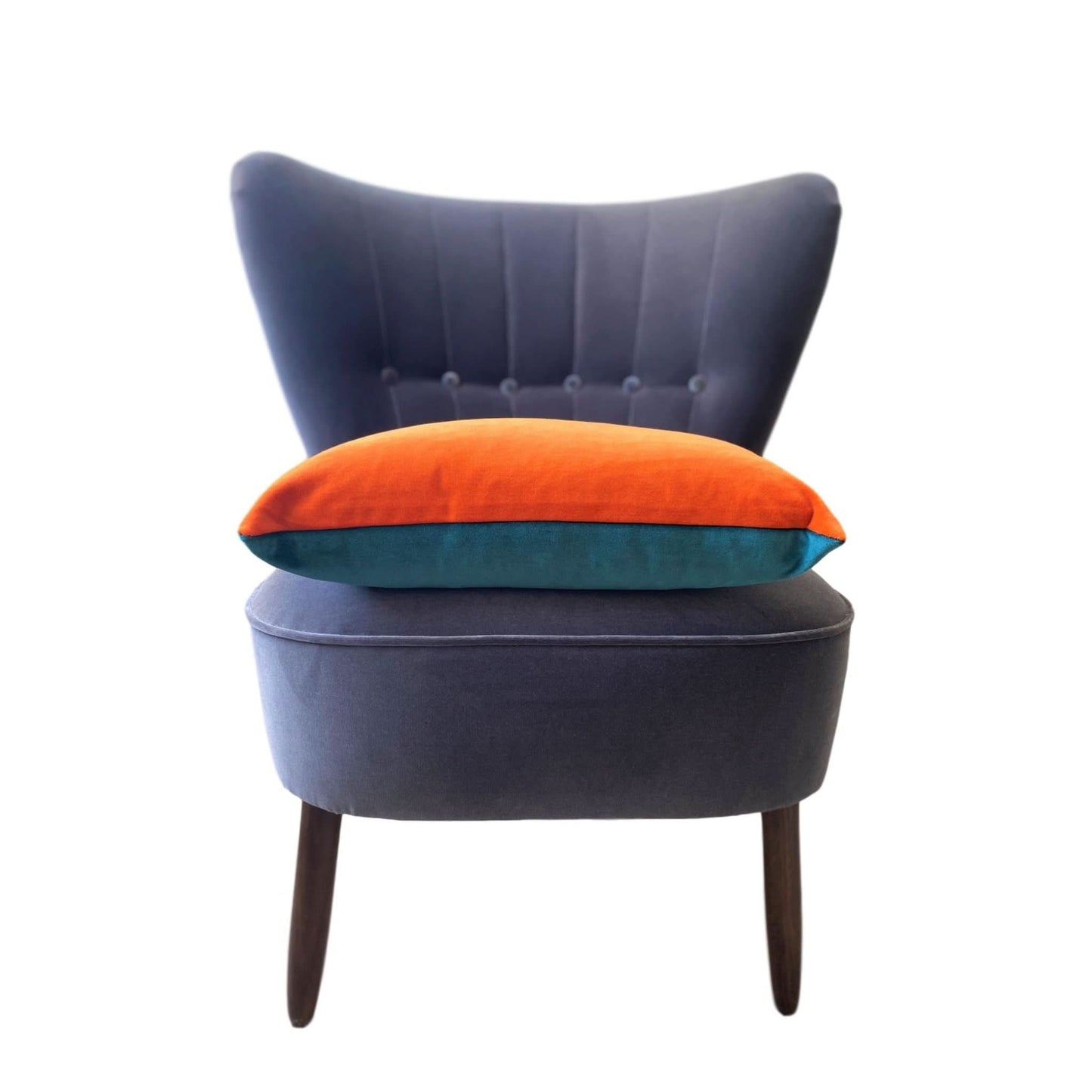 teal and orange cushion made of velvet on a dark grey velvet chair