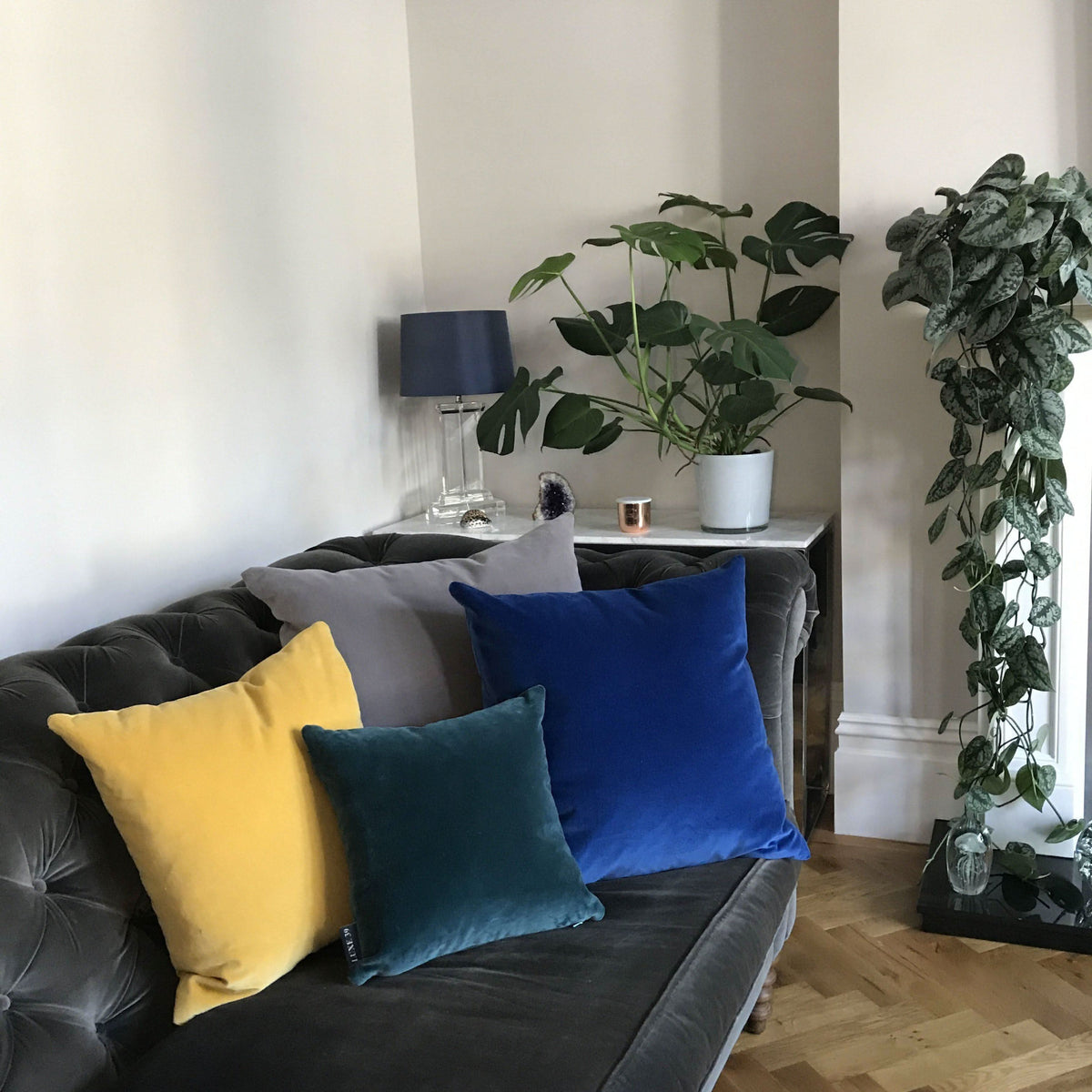 cobalt blue velvet cushion with teal on grey sofa