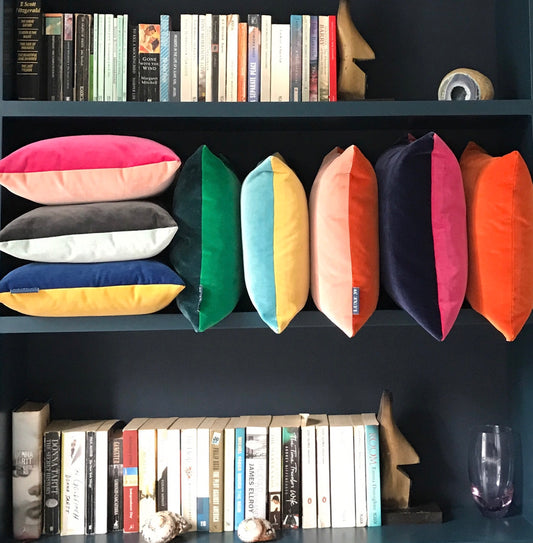 velvet cushions arranged on a bookcase