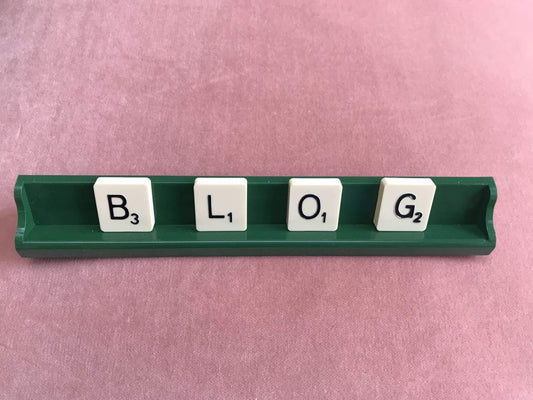 blog written in scrabble pieces on a pink velvet background