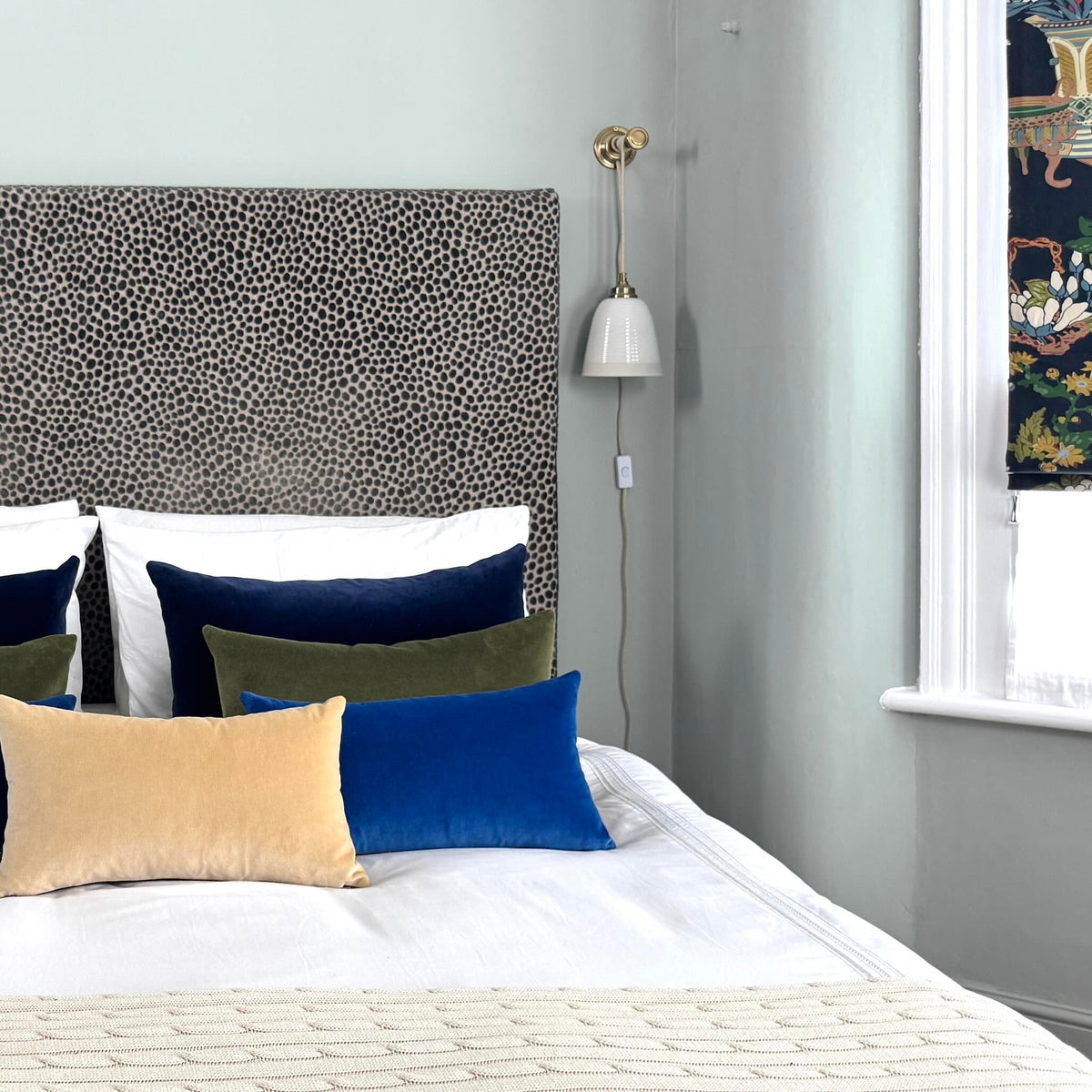 blue velvet cushions on white and cream bedding