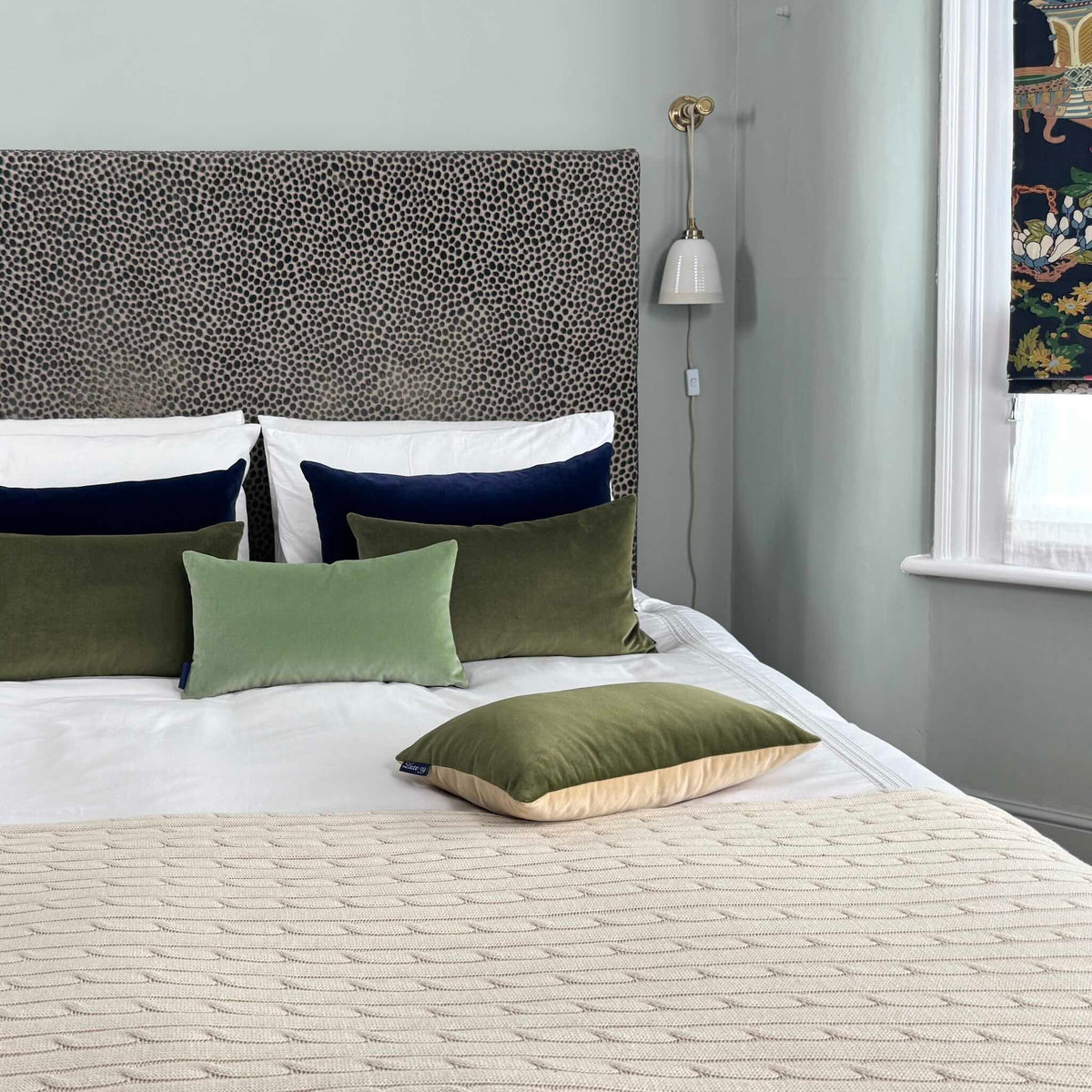 green velvet cushions on white and cream bedding