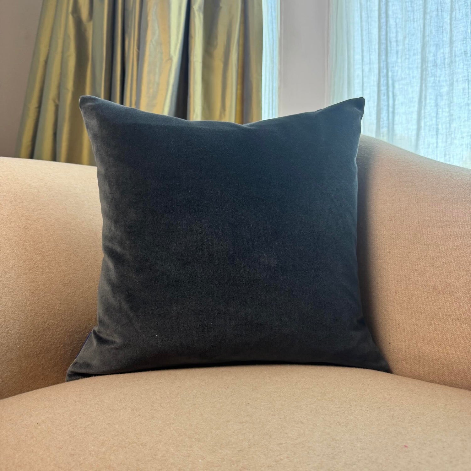 grey velvet cushion on beige sofa