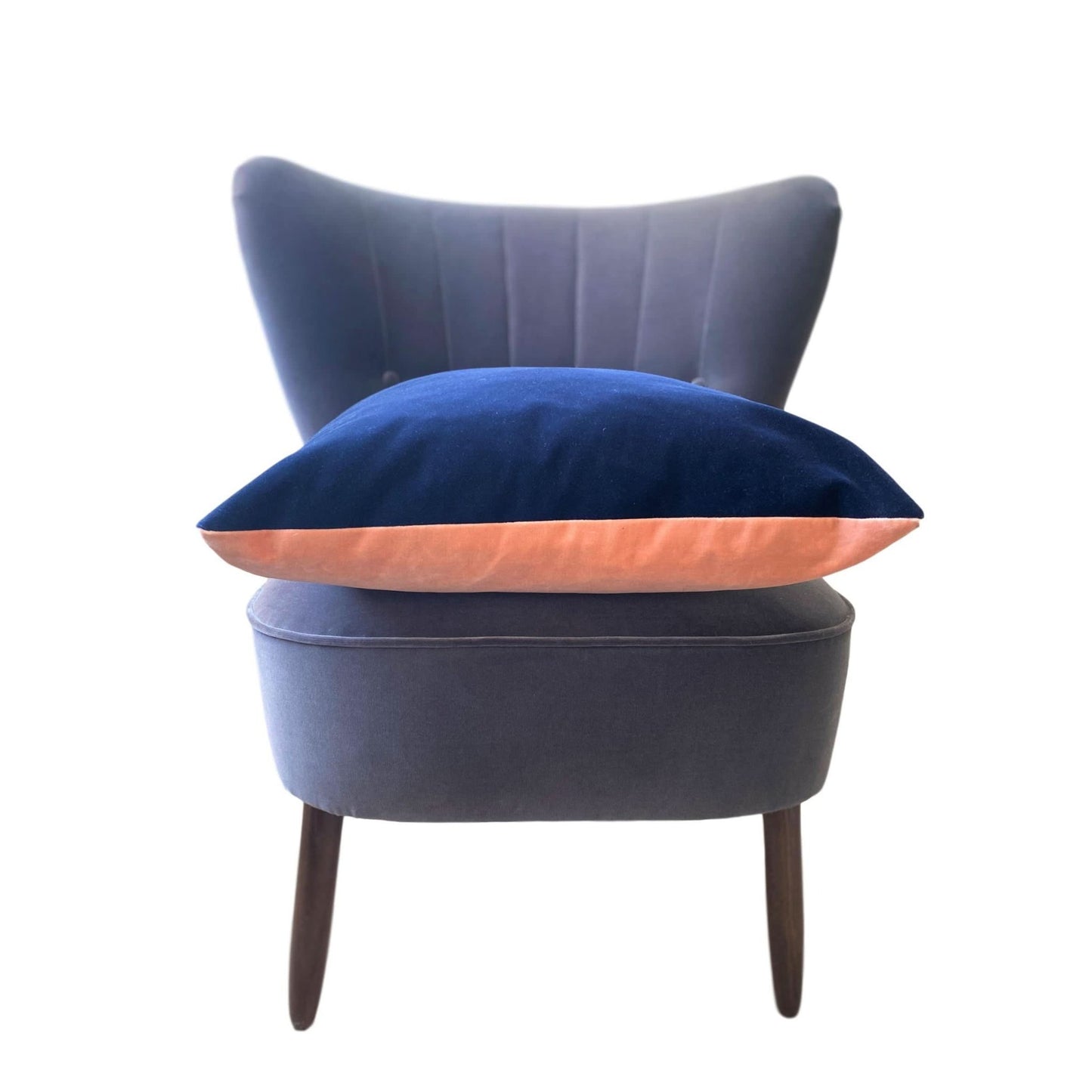 blush and navy velvet cushion on a dark grey velvet chair