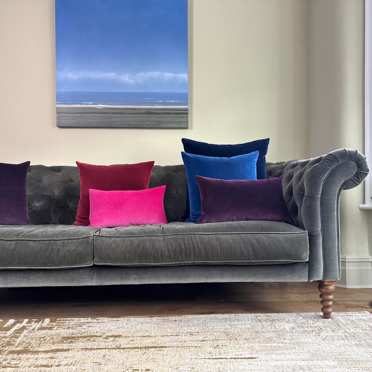 bright pink velvet cushion on grey sofa