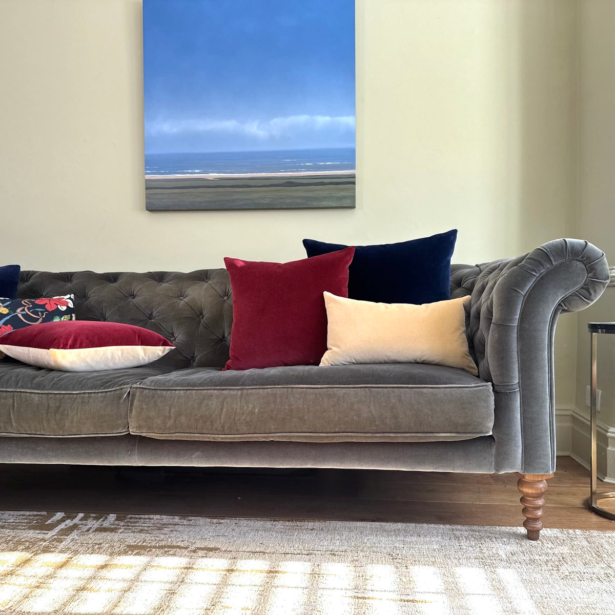 burgundy and champagne cushions on grey sofa