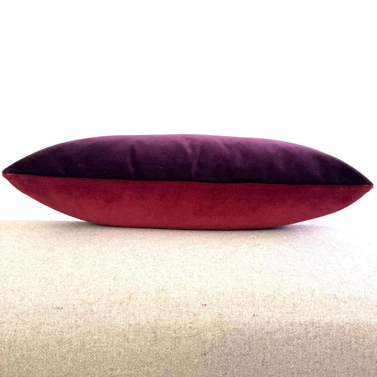 burgundy and plum reversible velvet cushion side view on beige stool