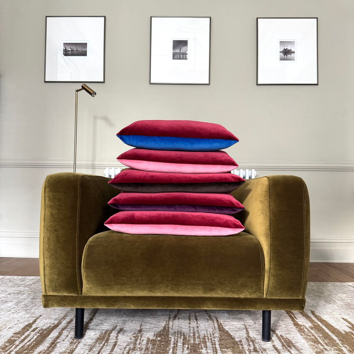 burgundy and rose pink velvet cushions stacked on olive green chair