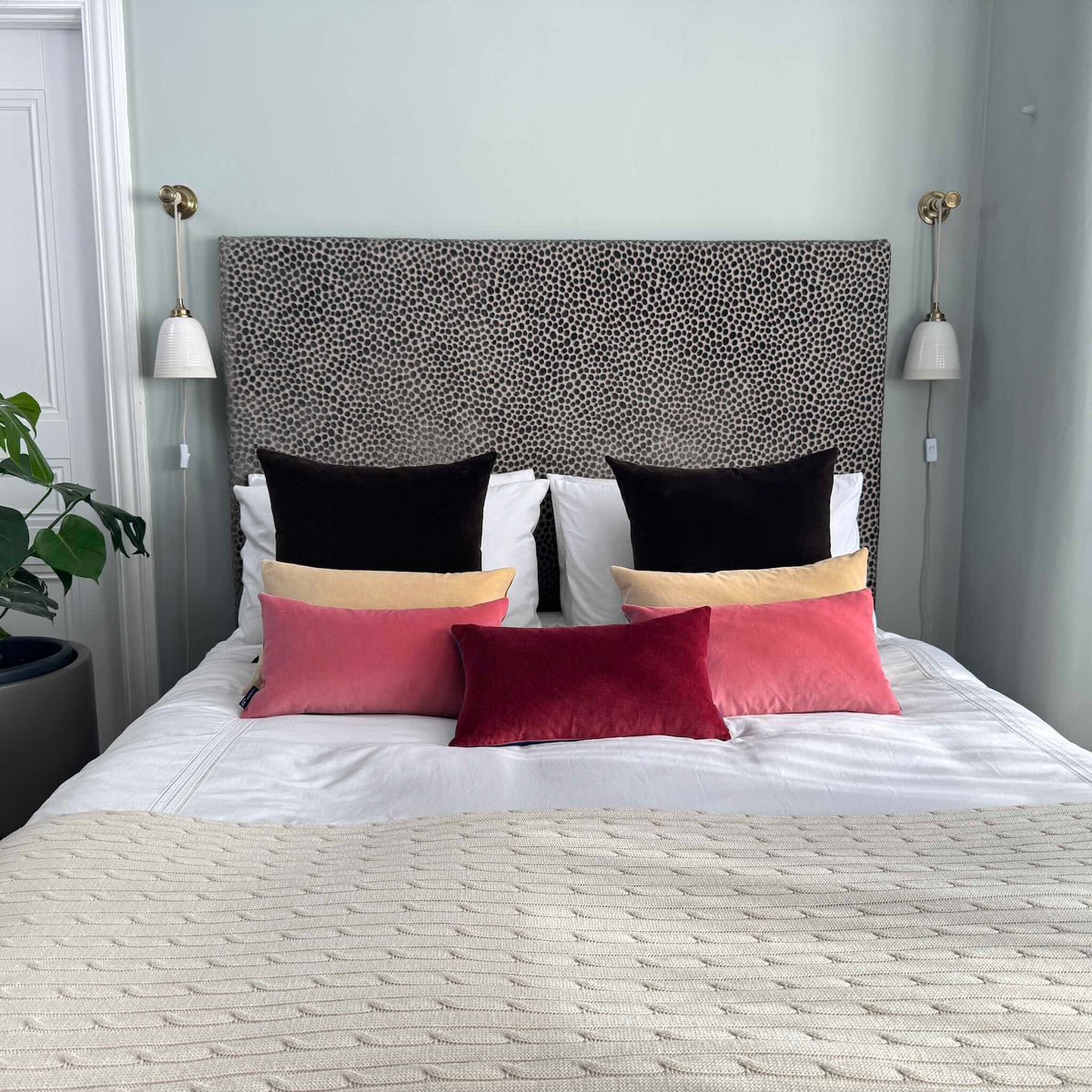 burgundy velvet cushion cover rectangle with pink and champagne cushions on white bedding in blue room