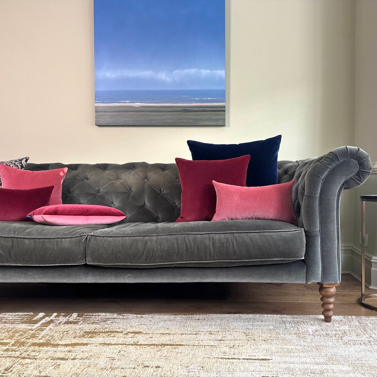 burgundy and rose pink cushions on a grey sofa