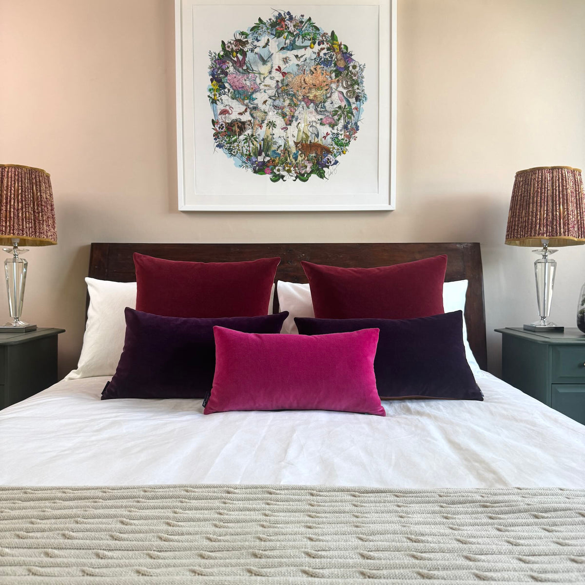 burgundy velvet cushions with other berry colours on wooden bed