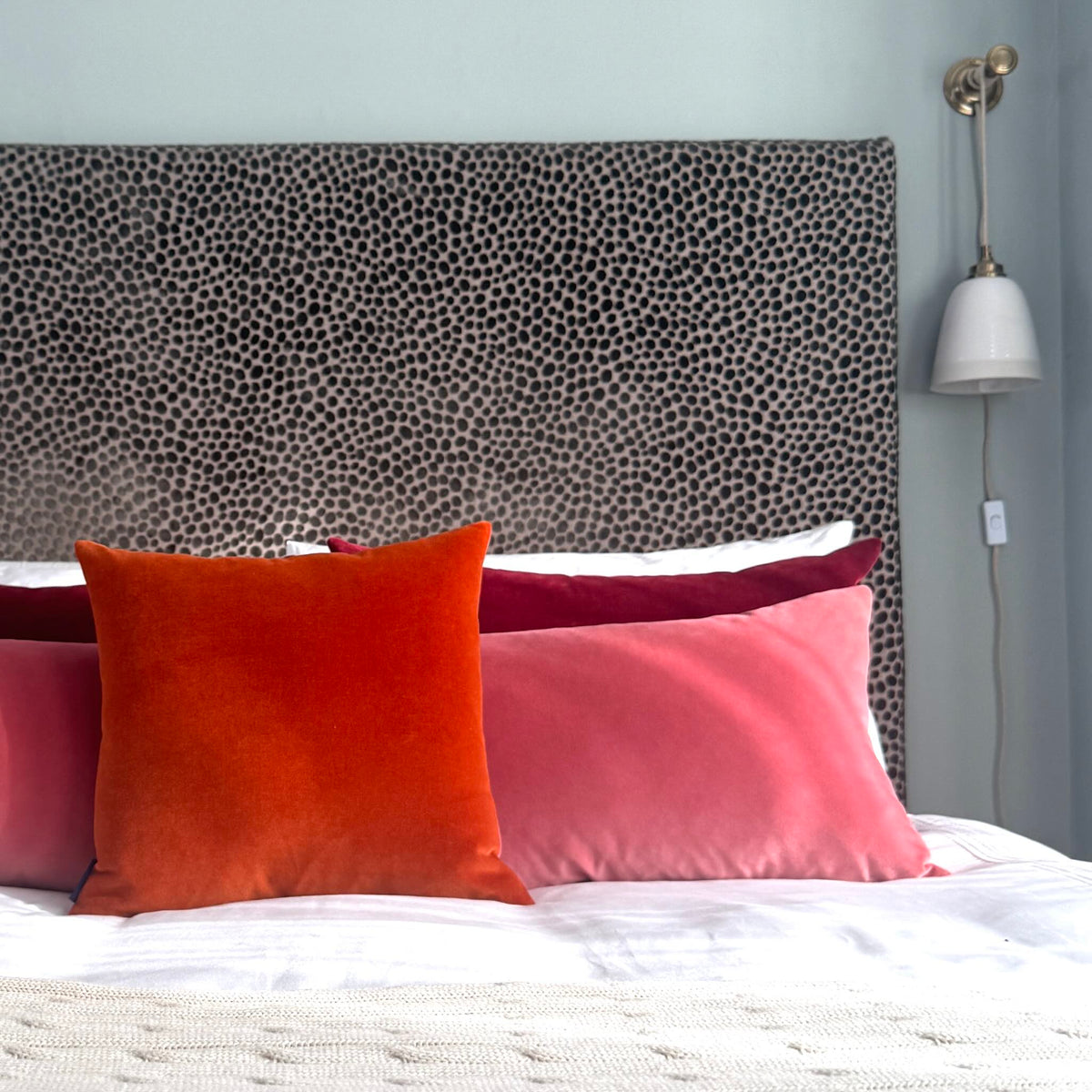 burnt orange velvet cushion cover with rose and burgundy in blue room