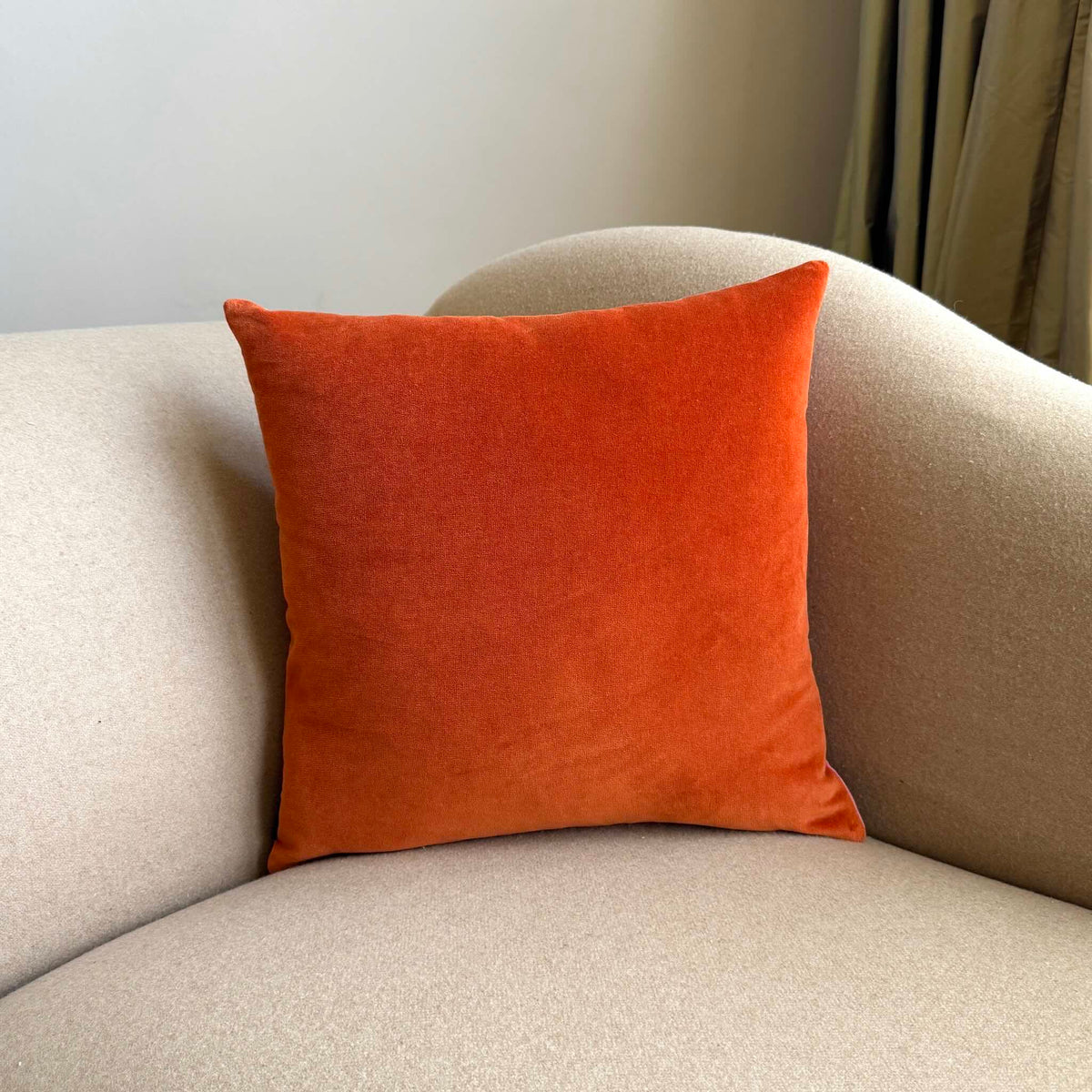 burnt orange cushion square on beige sofa
