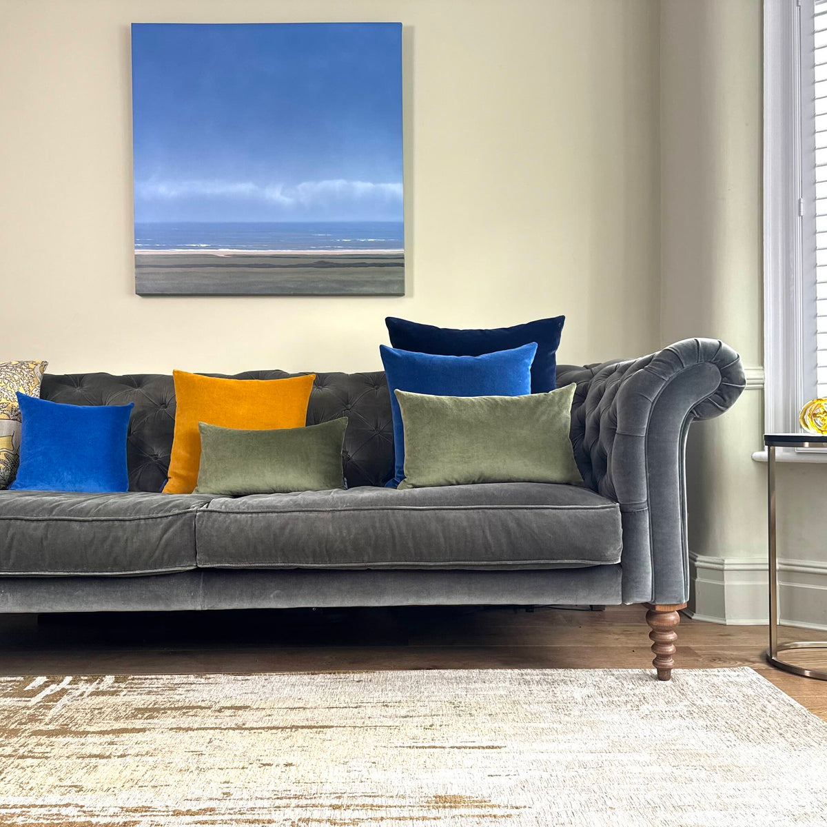 cobalt blue and luminous blue velvet cushions on grey velvet sofa