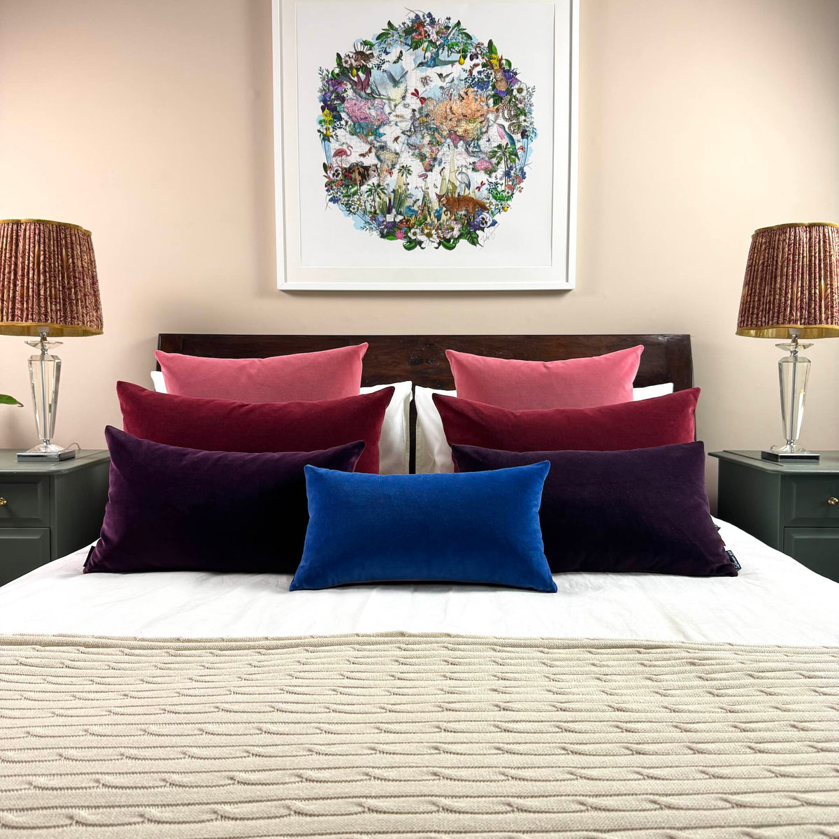 cobalt blue velvet cushion with berry colours on wooden bed