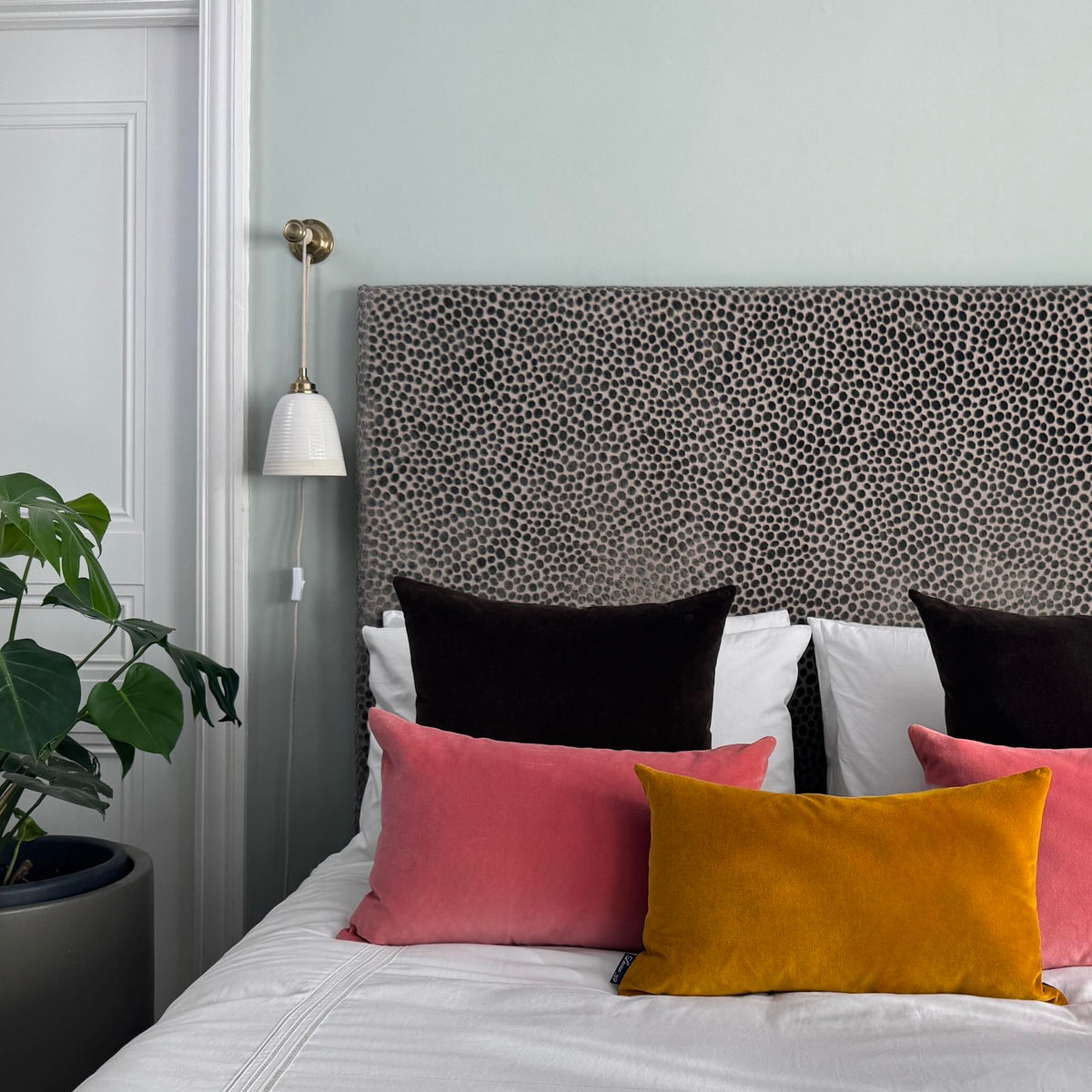 dark chocolate velvet cushions on white bedding blue room