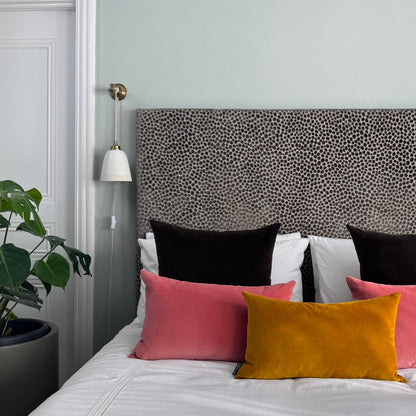 dark chocolate velvet cushions on white bedding blue room