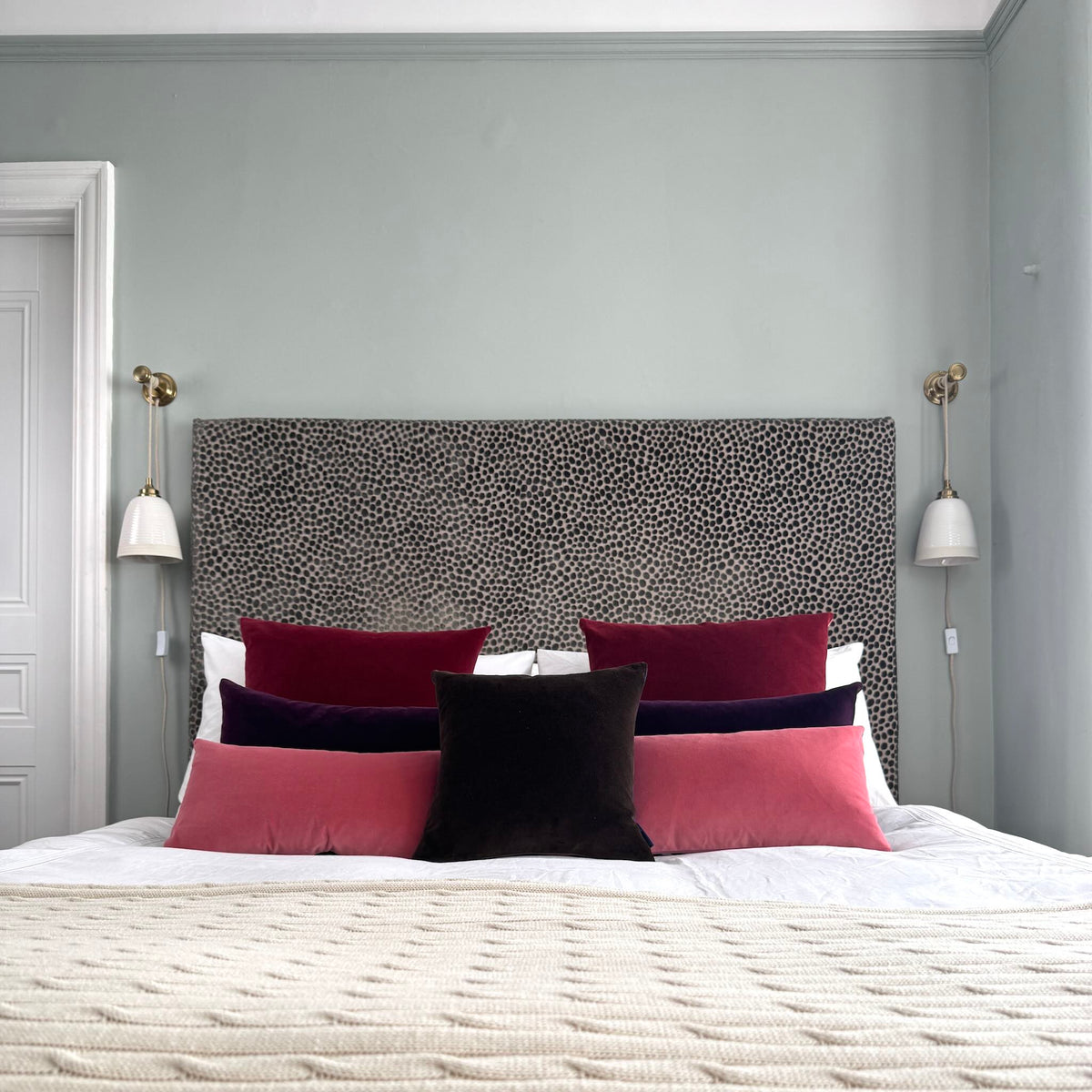 dark brown velvet cushion cover square with berry toned cushions on white bed
