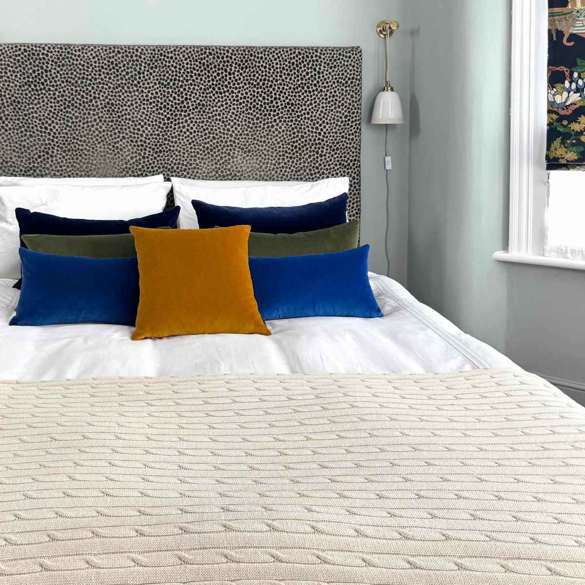 gold ochre velvet cushion with cobalt, olive and navy on white bedding
