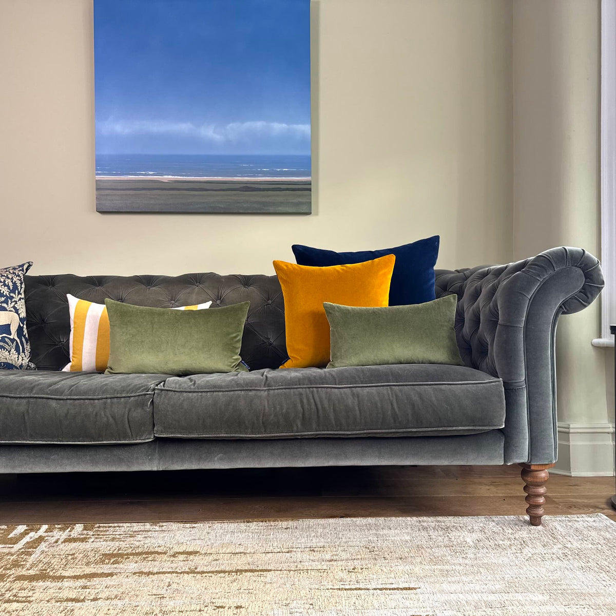 olive green velvet cushion on grey sofa