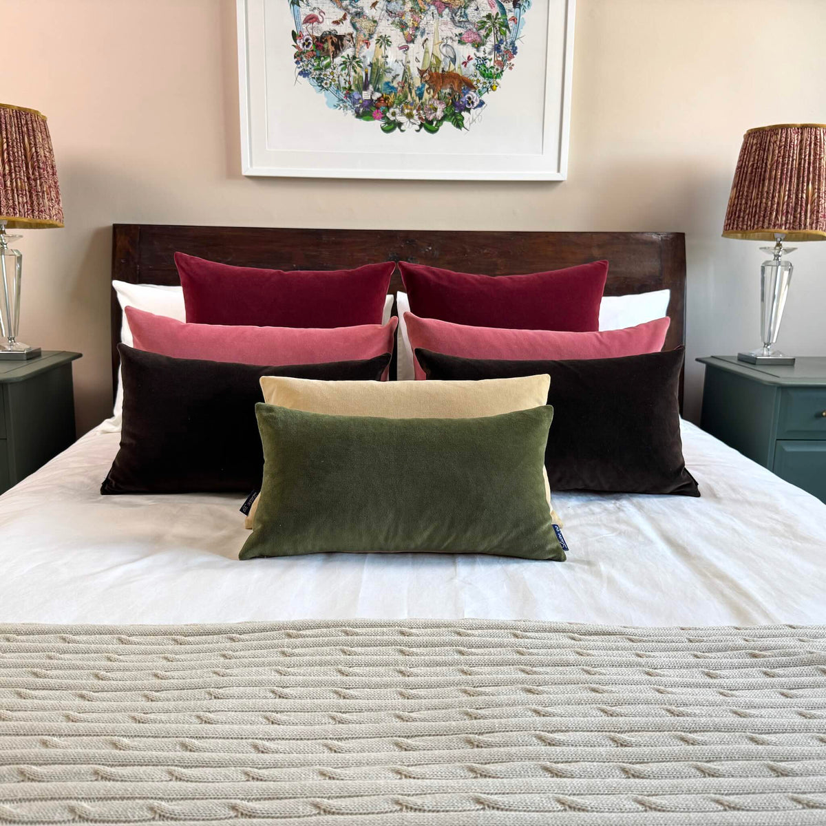olive green velvet cushion rectangle on white bedding on wooden bed
