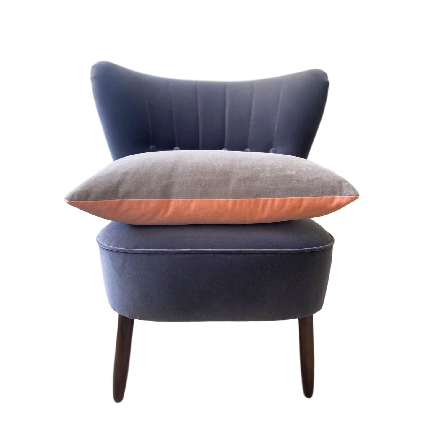 pink and grey cushion covers on a dark grey velvet chair