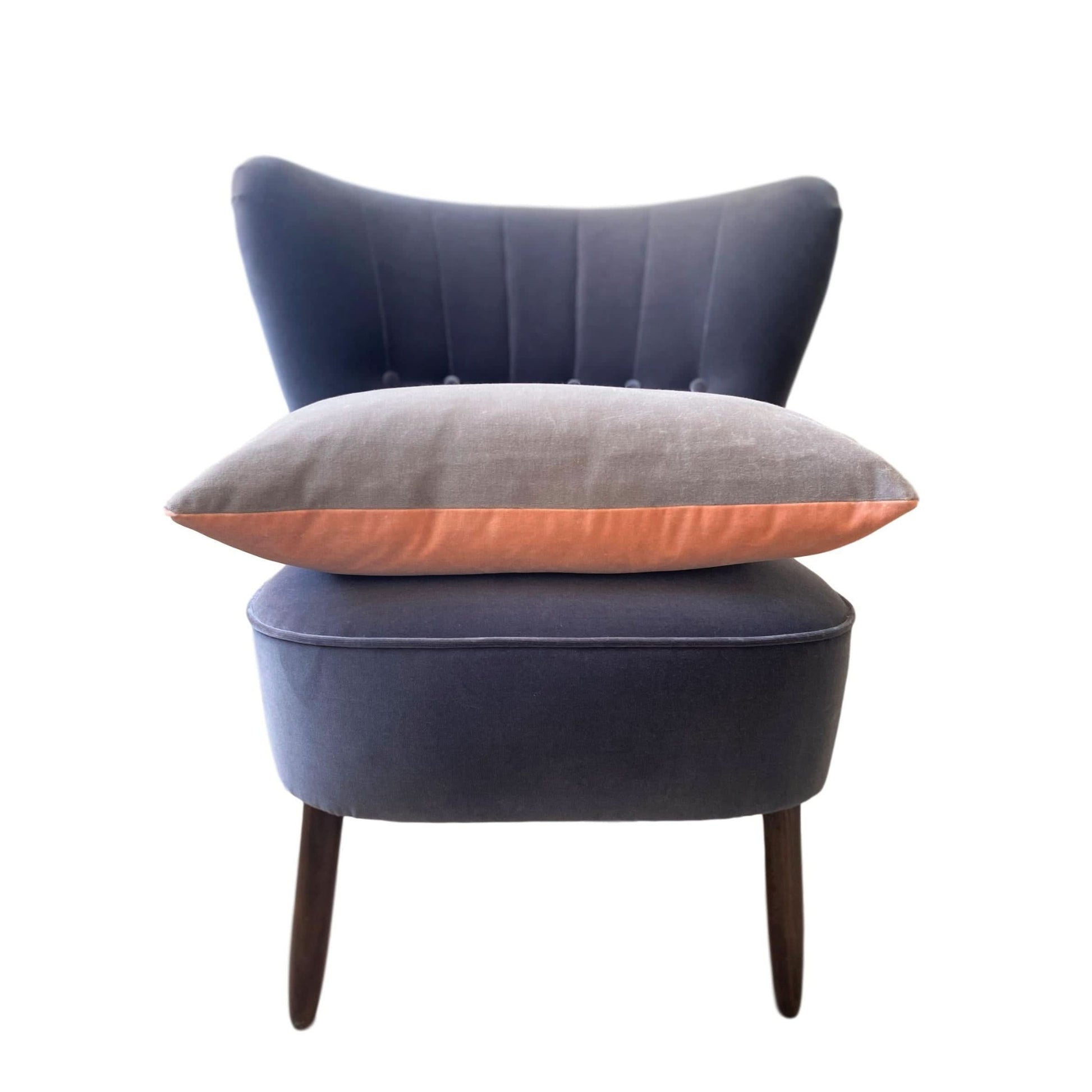 pink and grey cushion covers on a dark grey velvet chair