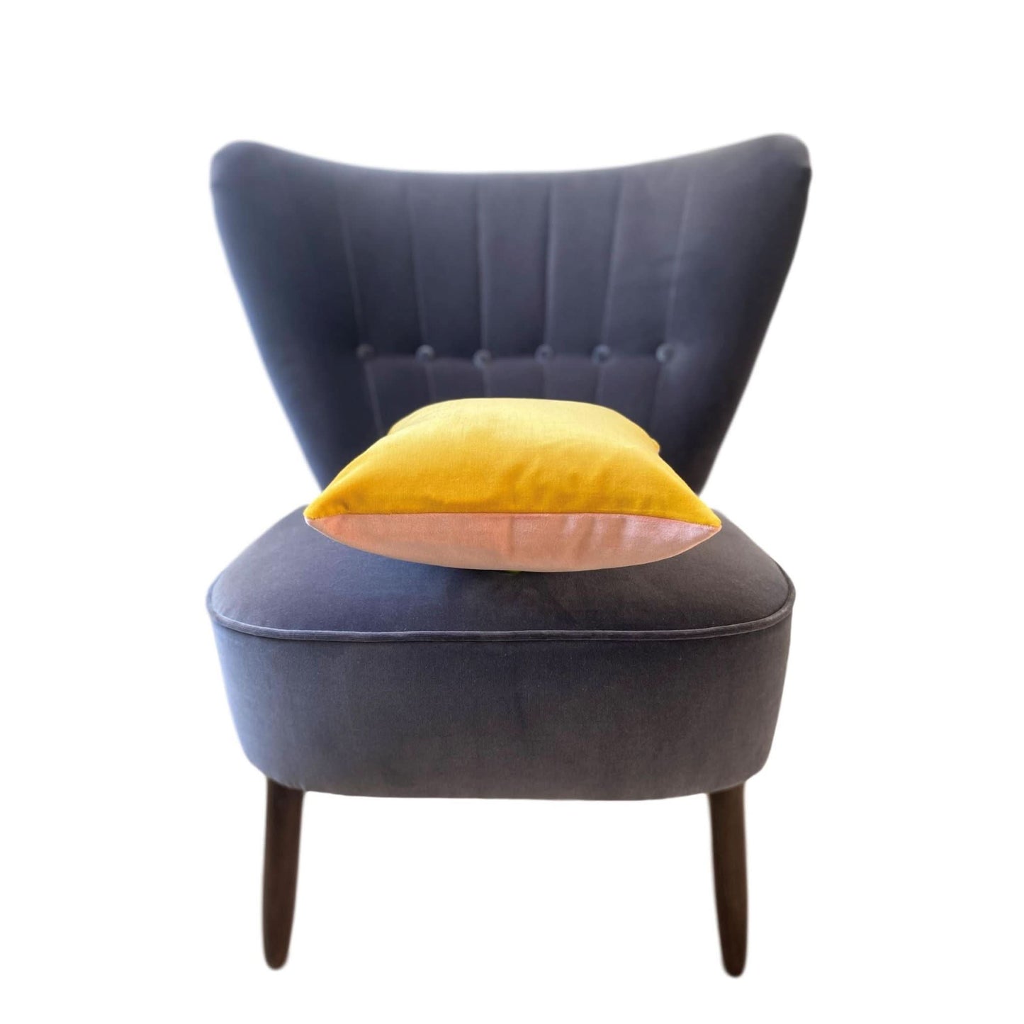 yellow and pink velvet cushion covers on a dark grey velvet chair