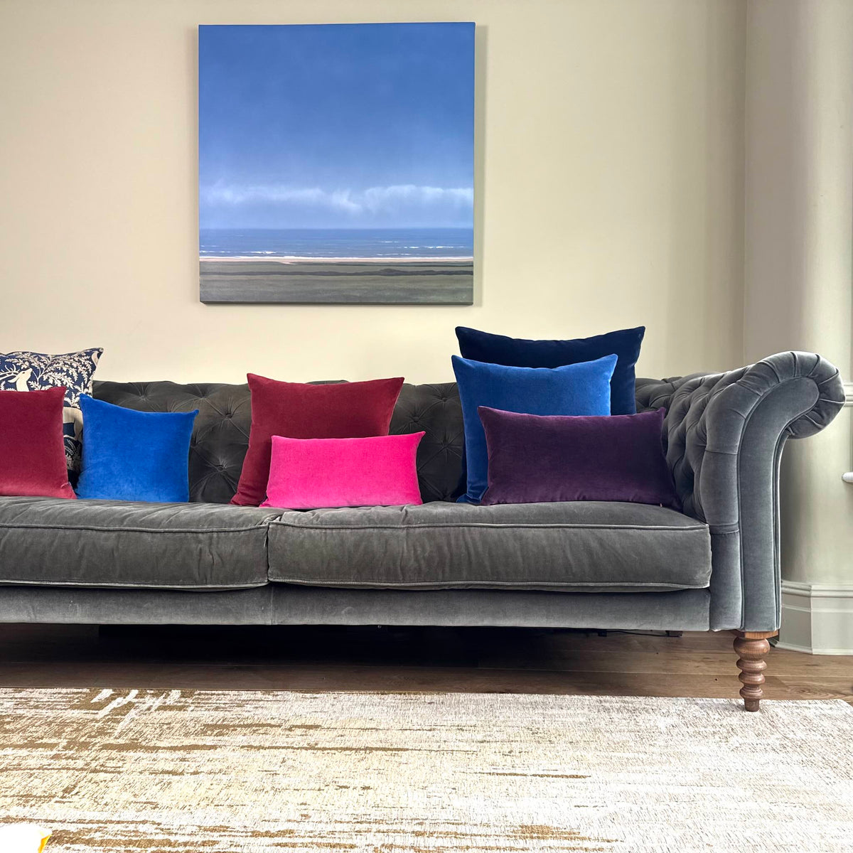 plum velvet cushion on a grey velvet sofa