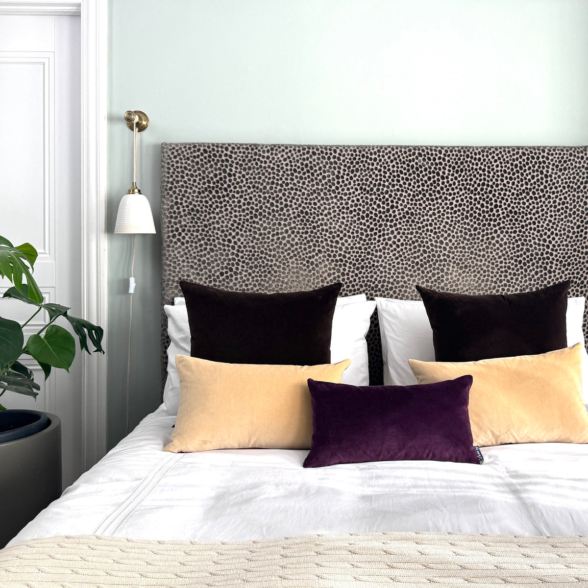 plum velvet cushion with champagne and dark chocolate in blue room