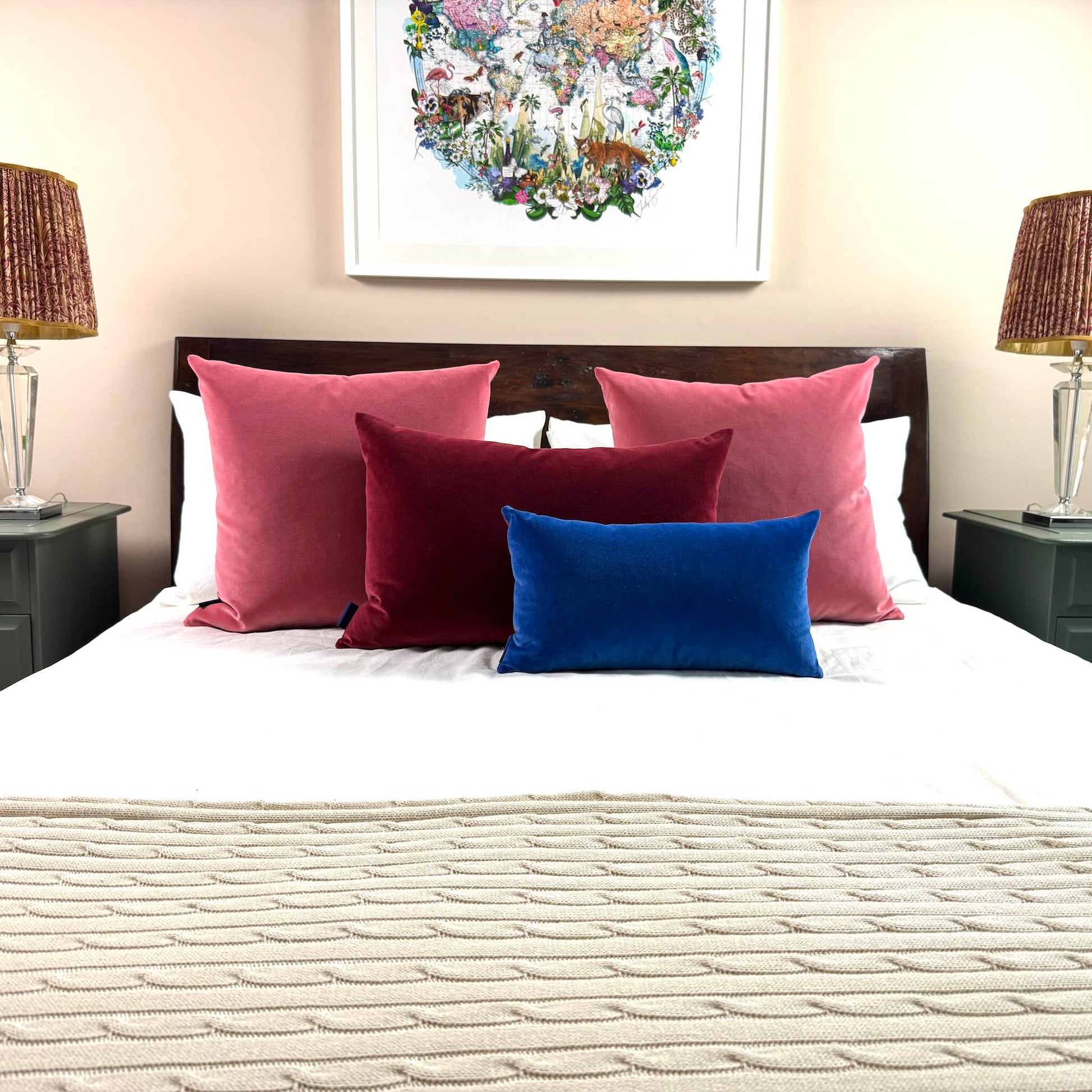 rouge pink velvet cushions styled on wooden bed with burgundy and cobalt cushions
