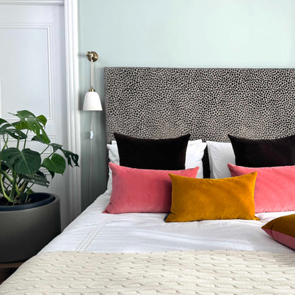 rouge velvet cushion with gold ochre and dark chocolate cushions in blue room