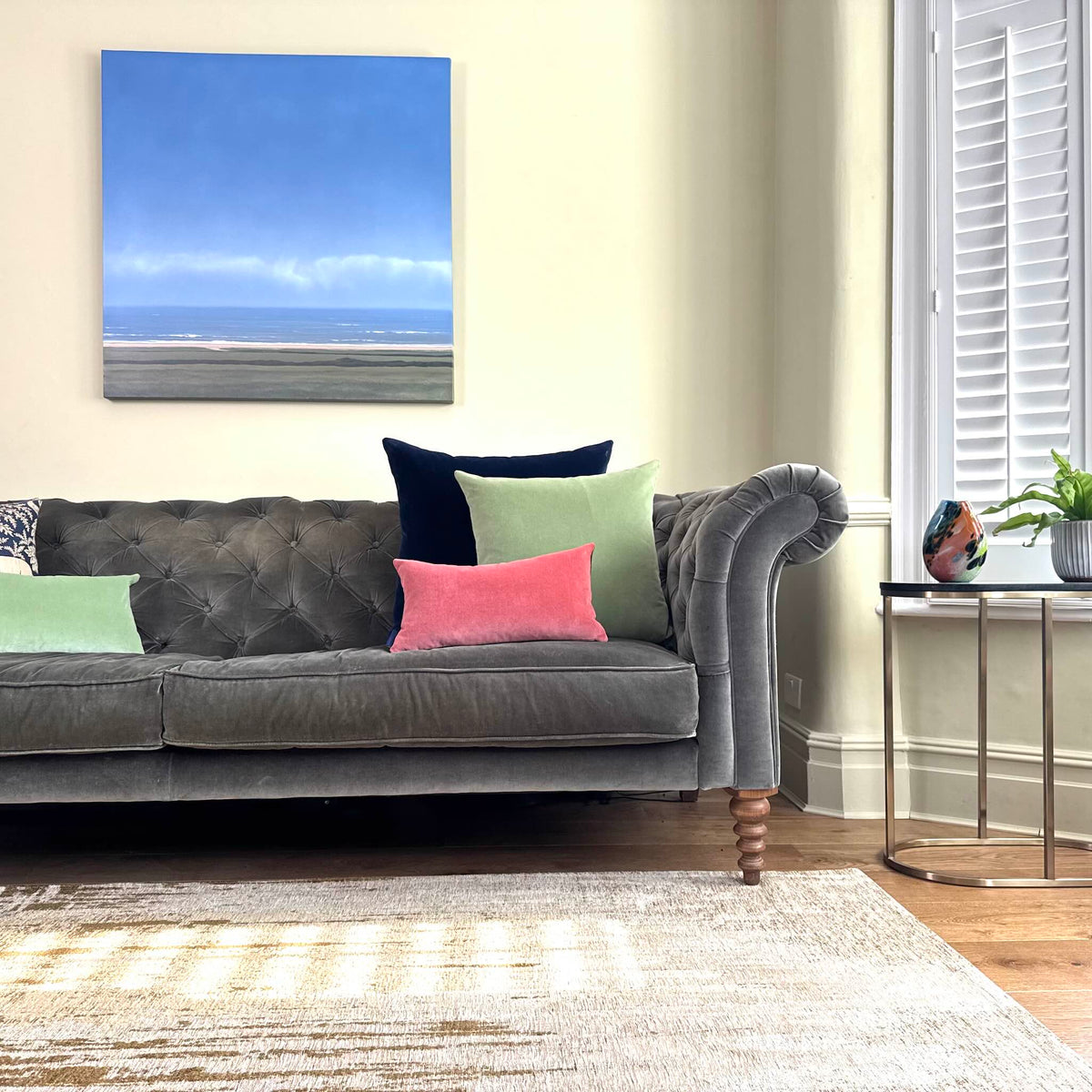 sage green velvet cushion covers with rose and navy on grey sofa