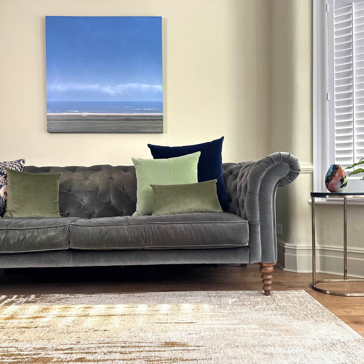 sage green velvet cushion on grey sofa