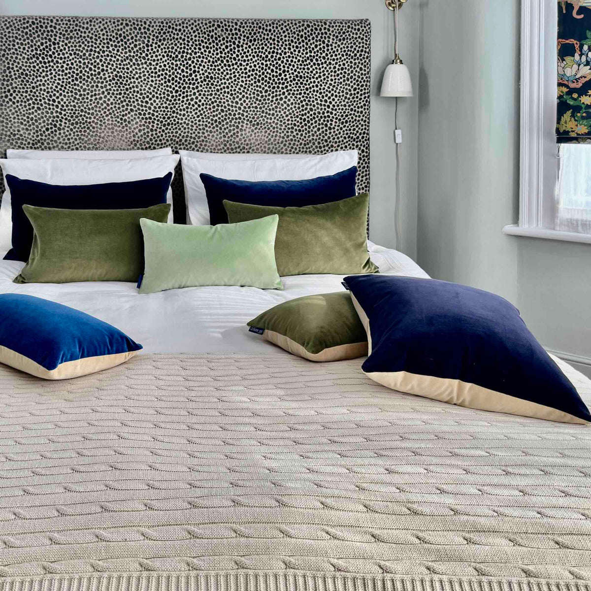 sage green velvet cushion with olive, navy and champagne on white bedding