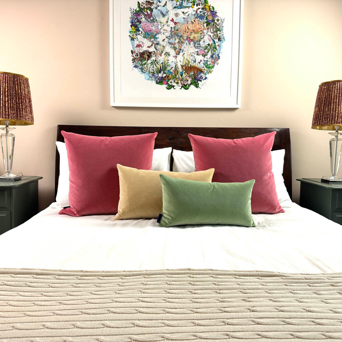 sage green velvet cushion on white bedding and wooden bed