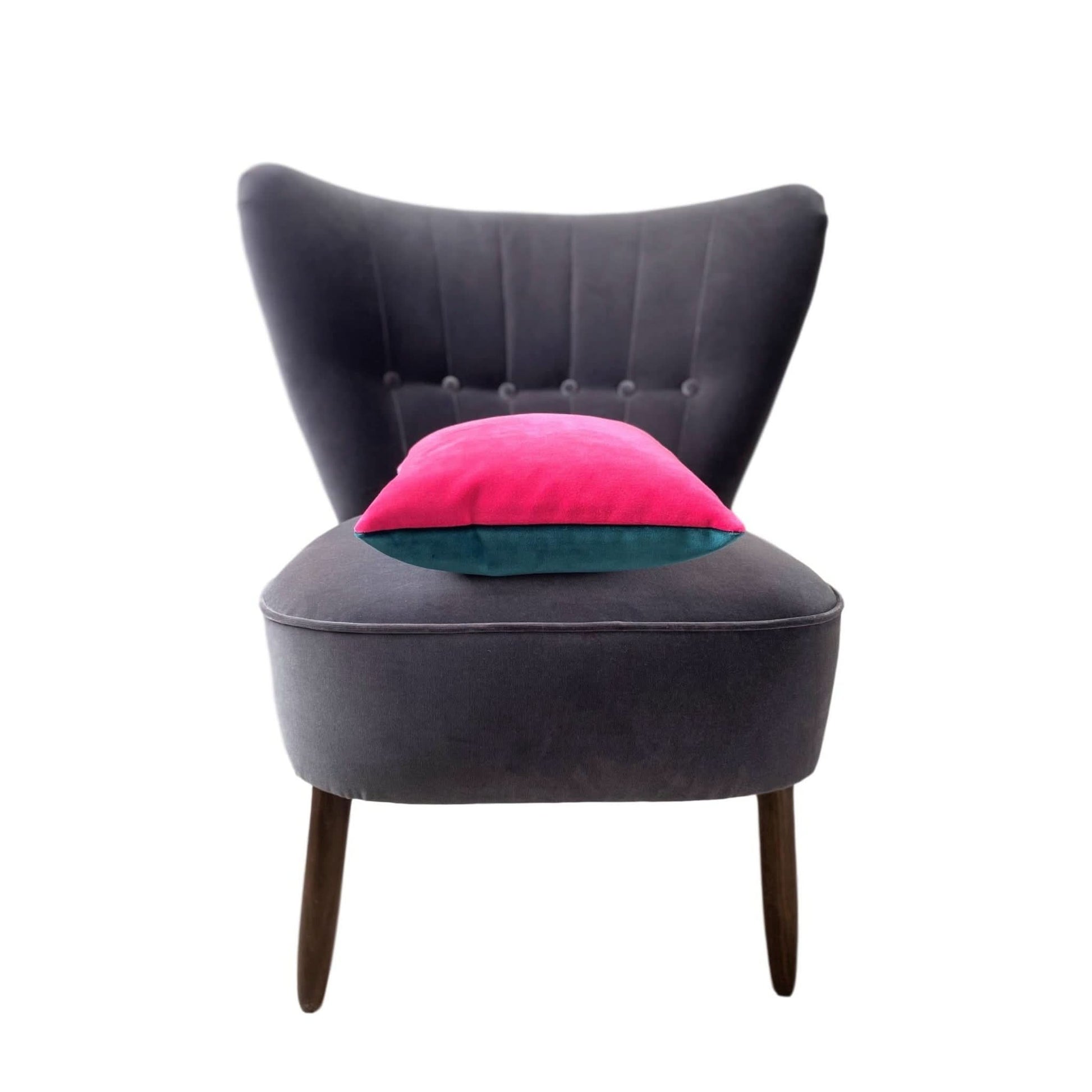 teal and pink cushion on a dark grey chair