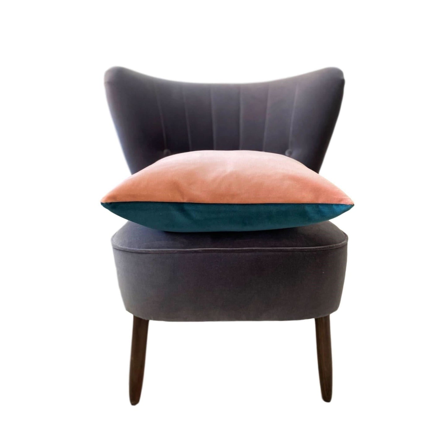 teal and pink cushion on a grey chair with a white background