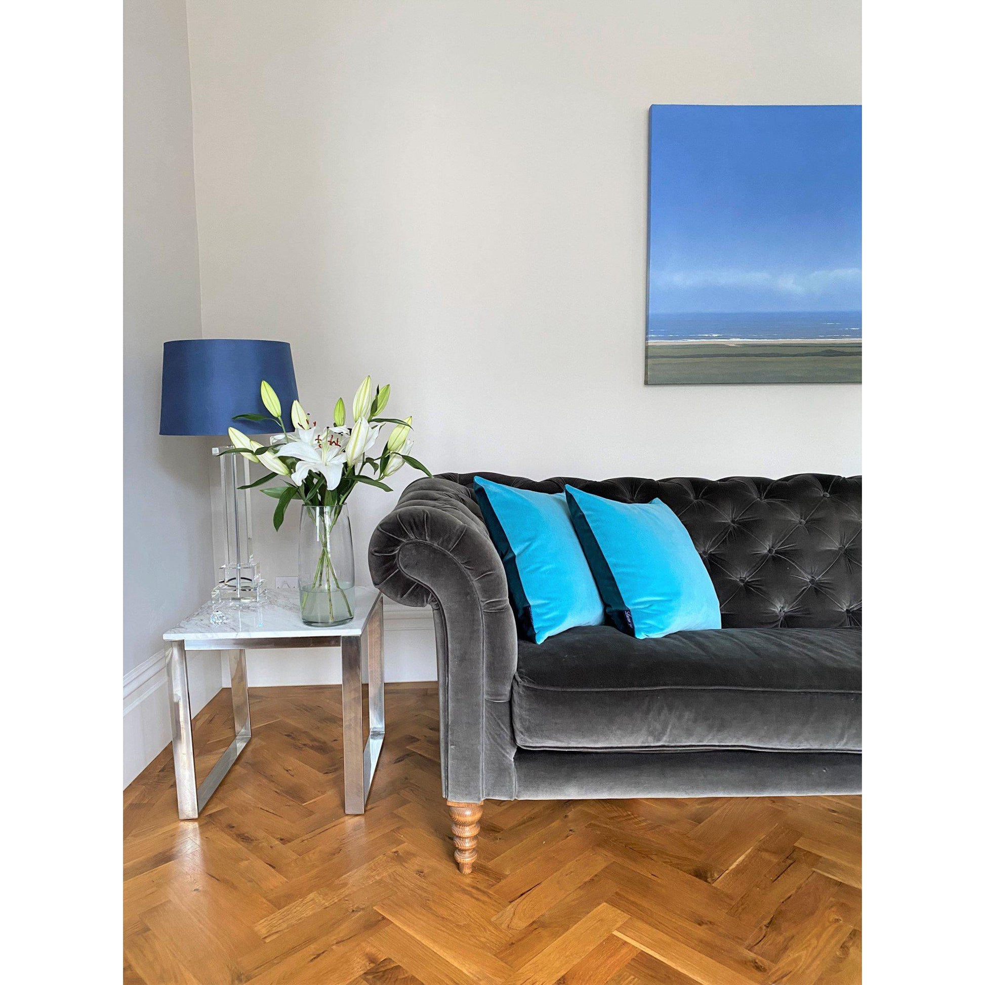 Turquoise velvet cushions with teal velvet reverse on a dark grey sofa