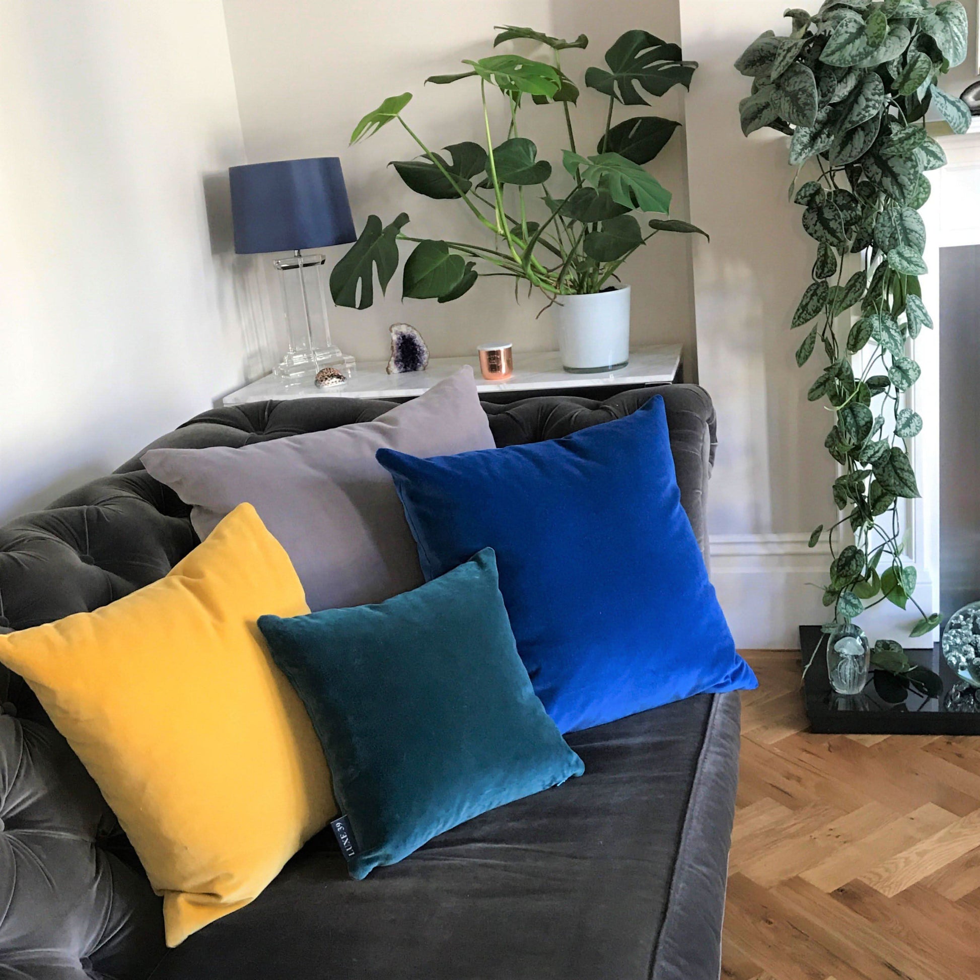 blue and grey cushions with teal and yellow cushions on a grey sofa