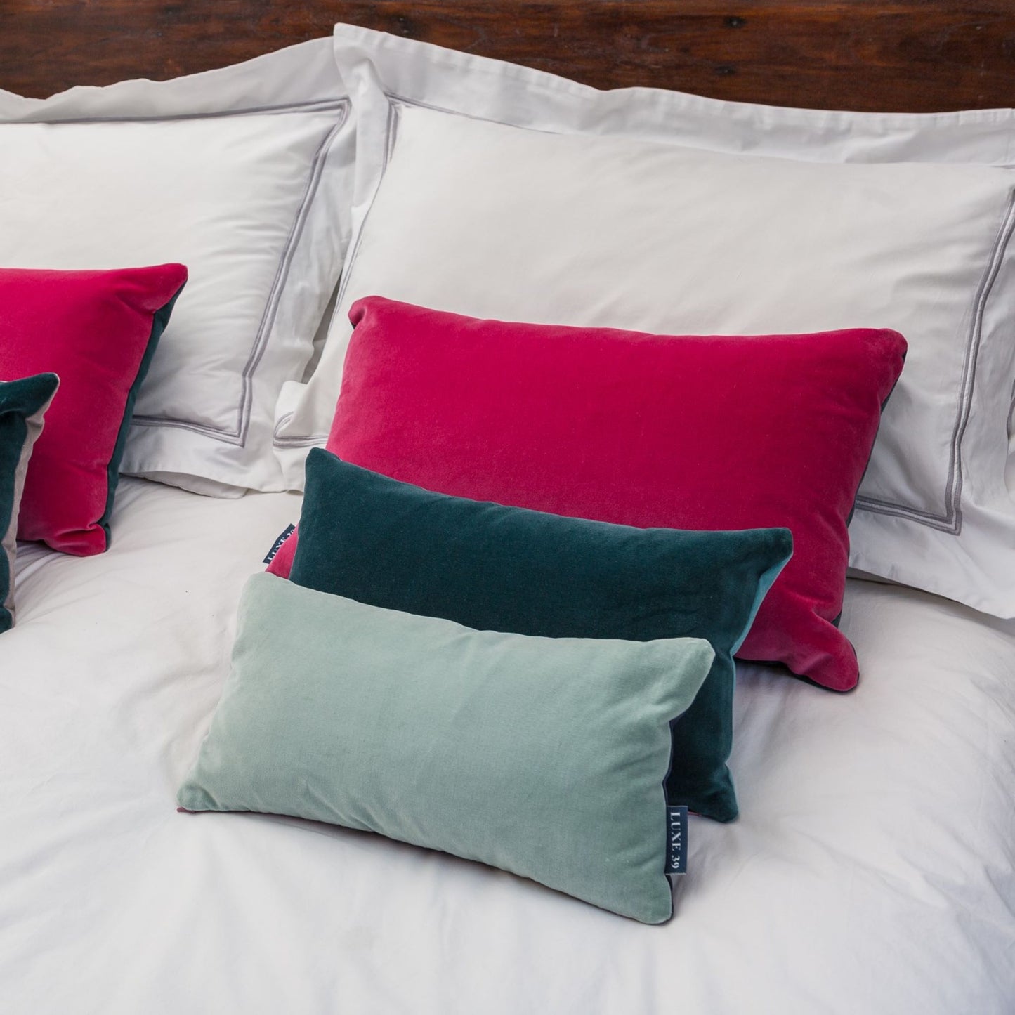 dark pink velvet cushion with teal and duck egg cushions